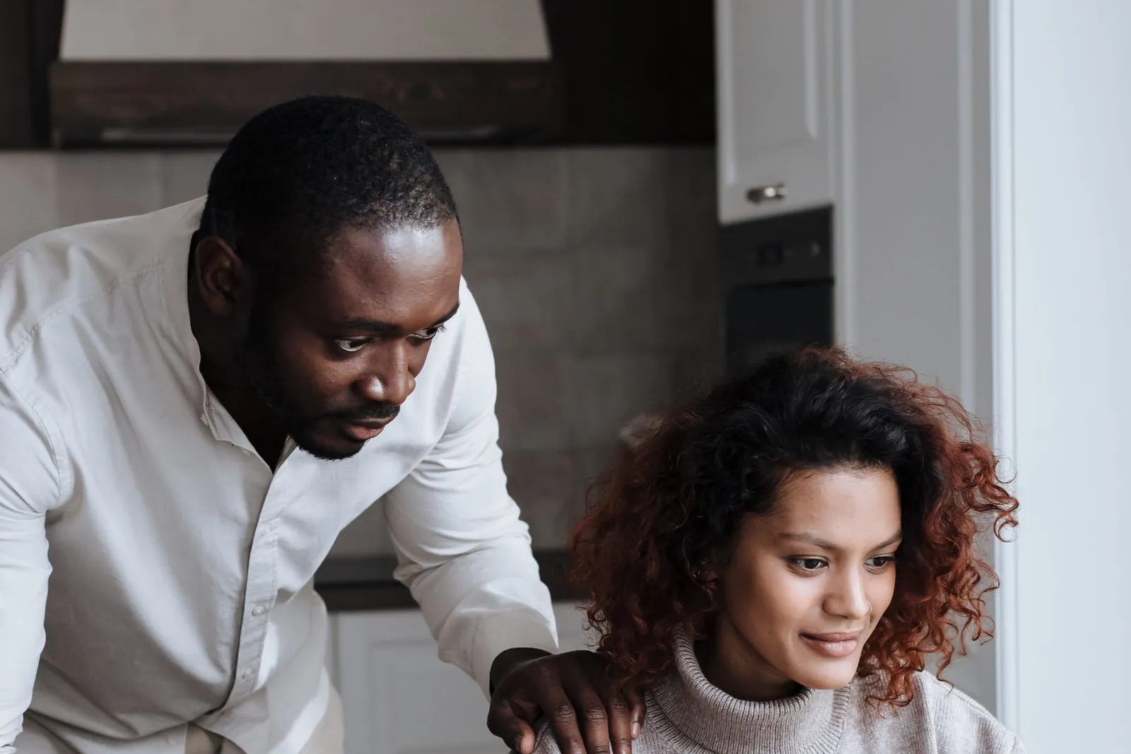 Couple planning together at a laptop in their kitchen